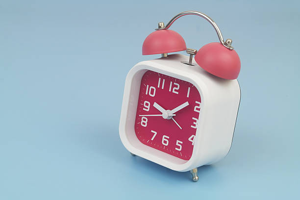 istock Red and white alarm clock on blue background. 2232469245