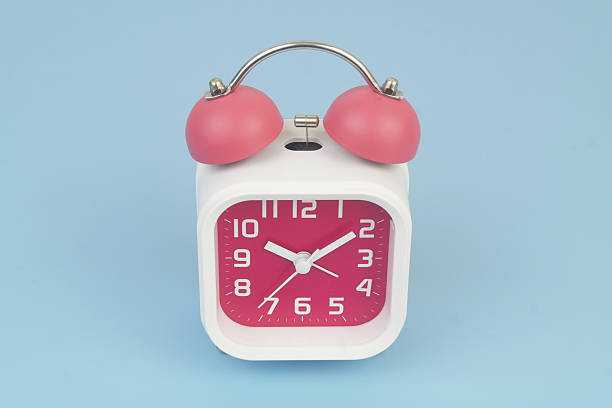 istock Red and white alarm clock on blue background. 2232469287