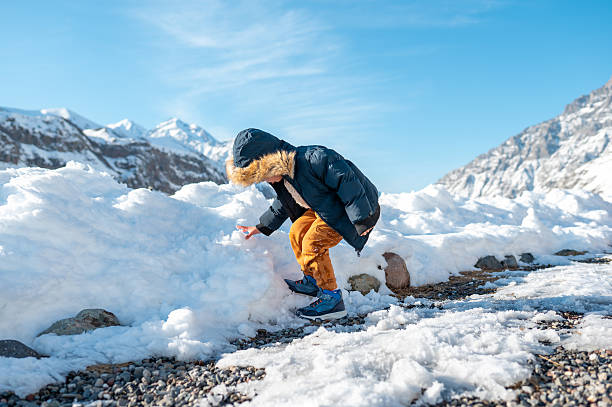 A curious child is exploring the snowy landscape, showcasing the thrill of winter play and the adventurous spirit, highlighting the connection between nature and childhood discovery.