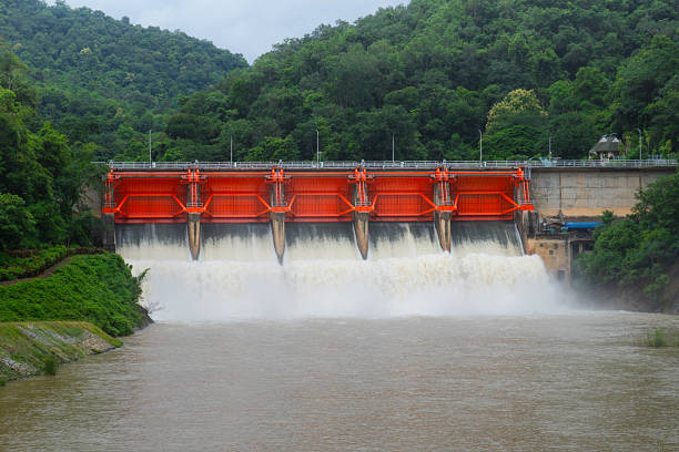 istock Hydro dam structure with open gates releasing muddy flood water. 2232469810