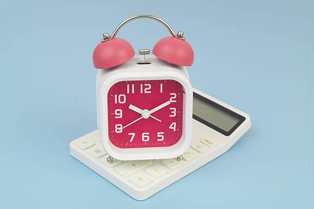 istock Alarm clock on calculator on blue background. 2232469894