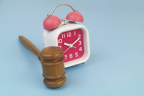 istock Wooden judge gavel and alarm clock on blue background. 2232470021