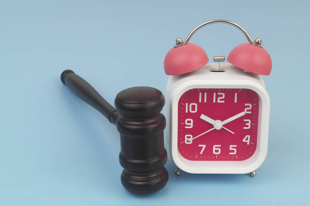 istock Wooden judge gavel and alarm clock on blue background. 2232471663