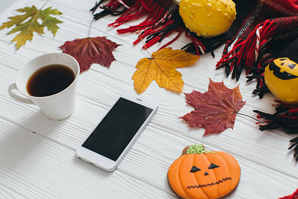 istock Autumn Halloween composition: smartphone, coffee, leaf, pumpkin, plaid and gingerbread. 2232472937