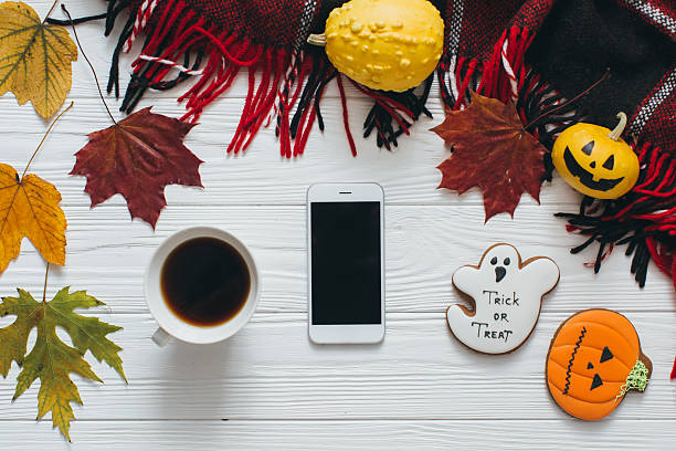 istock Autumn Halloween composition: smartphone, coffee, leaf, pumpkin, plaid and gingerbread. 2232472981