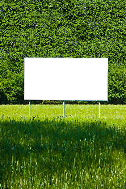 istock Blank advertising billboard immersed in a rural scene with trees on background - image with copy space 2232473379