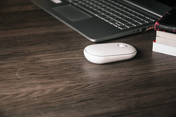 istock Computer mouse, laptop, and notebook on a wooden desk. 2232475808