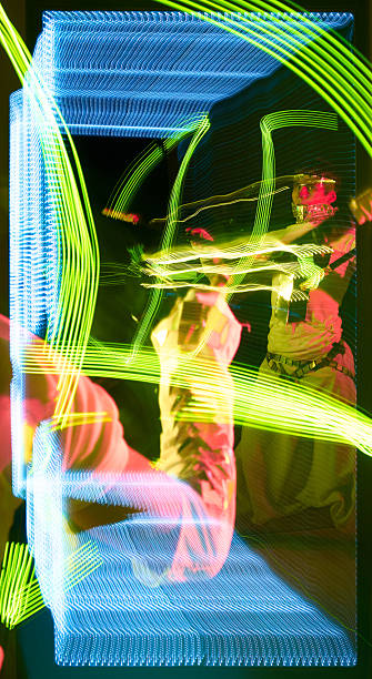 istock Young man light artist showing light patterns using LED poi reflecting in the mirror 2232479097