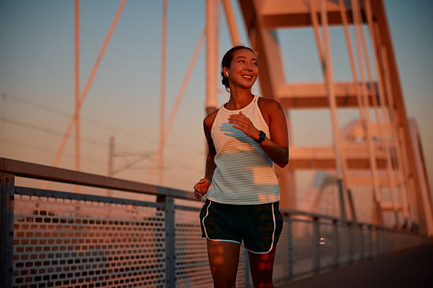 istock Young sportswoman running on a bridge at sunset 2232482121