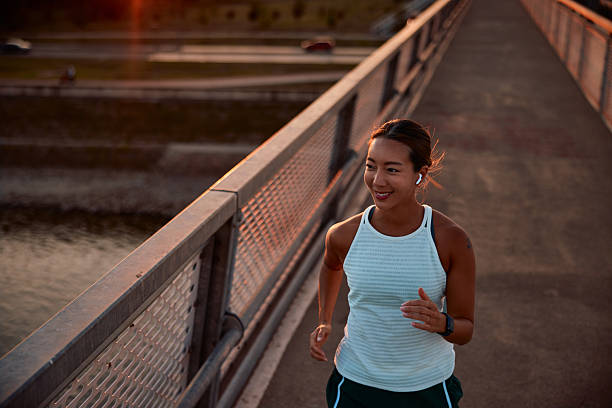 istock Young sportswoman running on a bridge at sunset 2232482147
