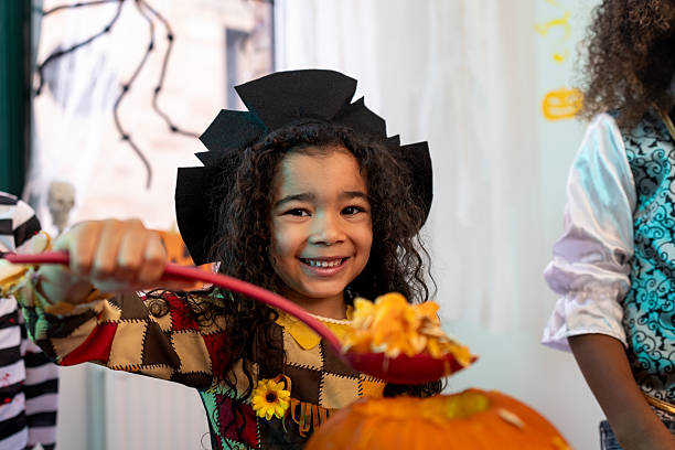 istock Happy Girl Scooping Out Pumpkin 2232484541