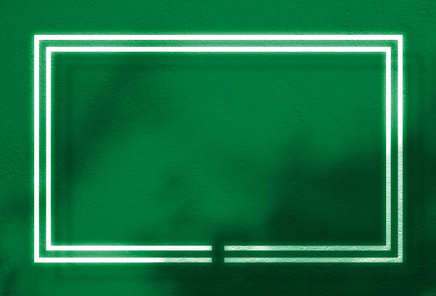 Modern background with vibrant green, textured wall. White neon double frame with bright, glowing effect centered on wall. Shadows unseen leaves cast subtle, organic pattern techno-natural