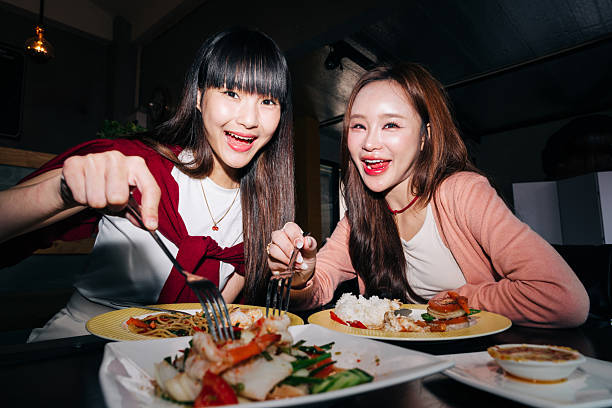istock Happy young women smiling while eating together 2232487933