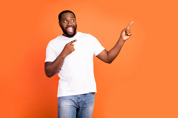 istock Portrait of attractive cheerful guy demonstrating copy empty space ad look idea isolated over bright orange color background 2232488666