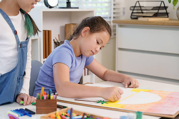 istock Caucasian elementary girl student concentrating on large crayon artwork at classroom desk representing creativity imagination dedication artistic childhood educational growth learning activity 2232489954