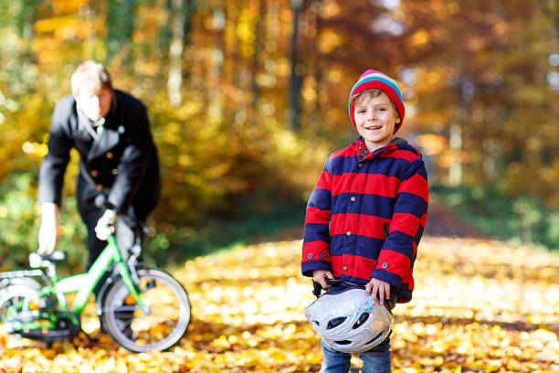 Little boy, learning how to ride a bike in the park, springtime