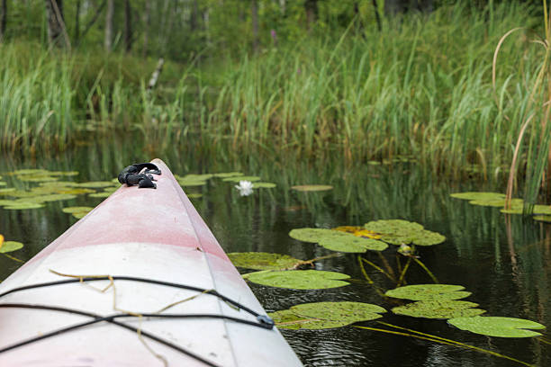Kayak boat next to lake at the mountain at sunset.