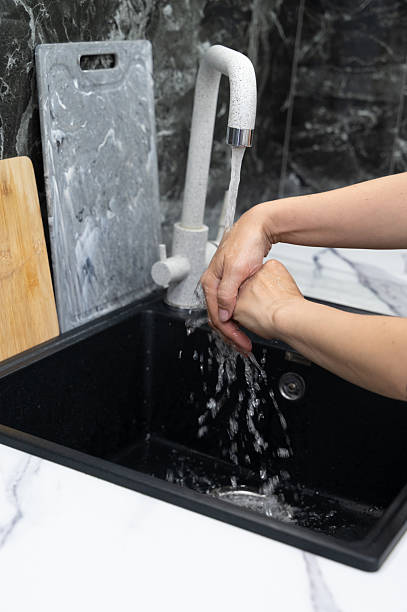 istock Washing Hands at a Modern Kitchen Sink Designed Elegantly with a Stylish Aesthetic 2232494125