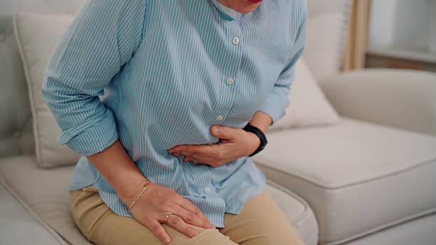 istock Asian older woman experiencing abdominal discomfort while alone at home 2232495641