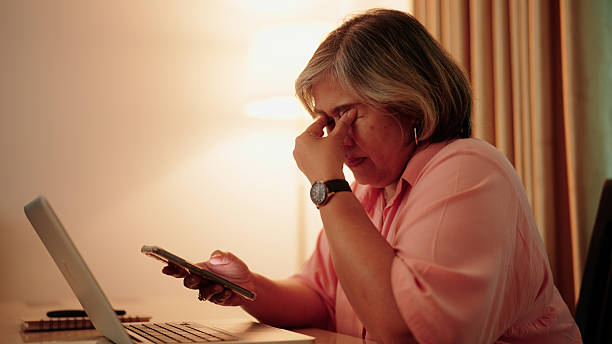 Asian older woman experiencing digital fatigue after extended smartphone use
