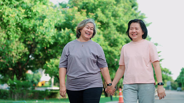 istock Senior lesbian couple holding hands while strolling through the park in the evening 2232495726