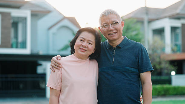 istock Older couple standing side by side in front of their residence 2232495799