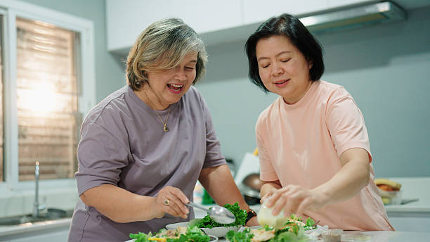 istock Two joyful elderly women preparing fresh salads together in the kitchen for dinner 2232496137