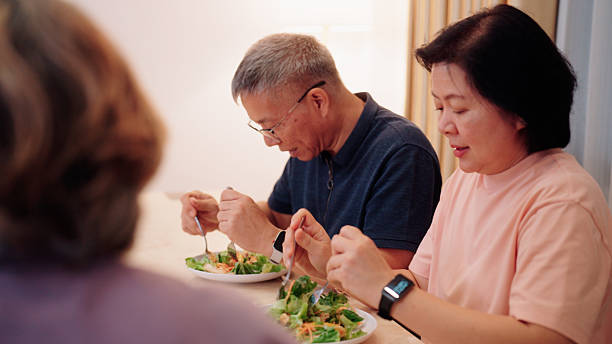 istock Three elderly individuals happily enjoying salads together at the dining room table 2232496150
