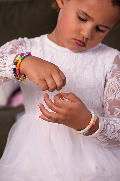 istock Young Girl Threading Beads for Handmade Jewelry. 2232496546