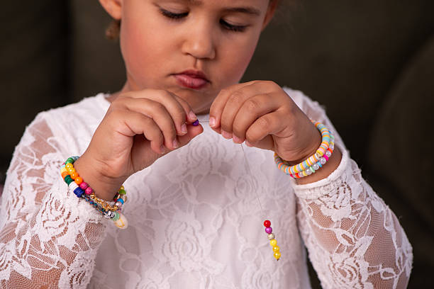 istock Focused Child Stringing Colorful Beads for Handmade Jewelry. 2232496636