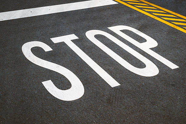 istock White stop sign painted on asphalt, symbolizing caution and pause. 2232497373
