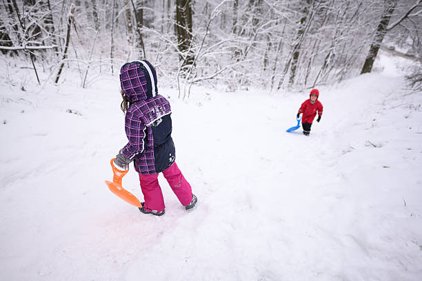 istock Children playing with sleds in snowy forest on winter day 2232497922