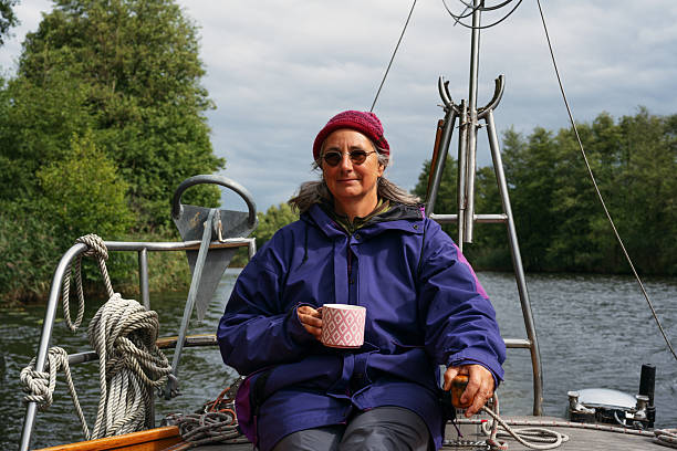 Hand of young successful businesswoman turning sailing wheel while leading large ship