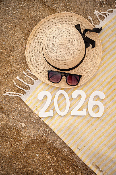 Beach towel, straw hat and sunglasses welcoming 2026