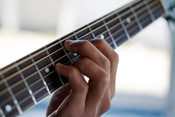 istock Fingers playing the guitar close-up 2232501089