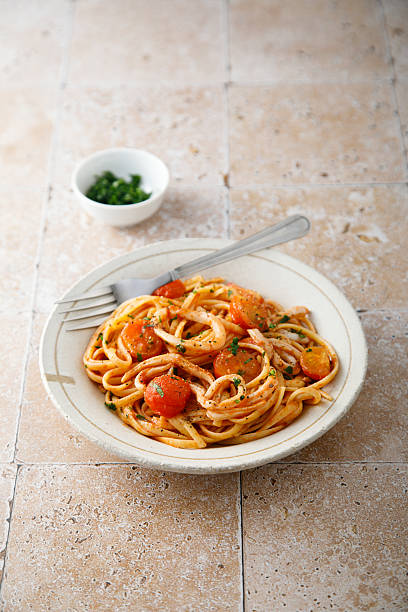 Pasta with tomatoes and squid stock photo