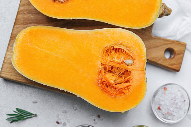 istock Half butternut squash on wooden board with salt and rosemary 2232503827