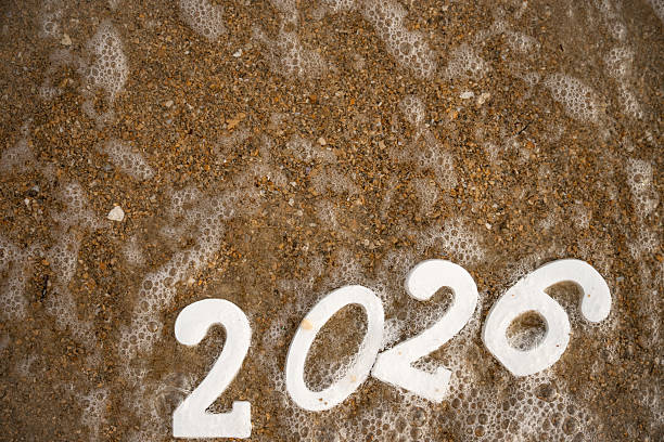 istock 2026 written in the sand with sea foam approaching 2232504317