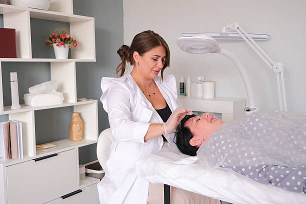 istock A cosmetologist making face massage to a client, taking off protective head band 2232504750
