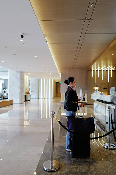istock Woman at hotel check-in hands a document to receptionist 2232505016