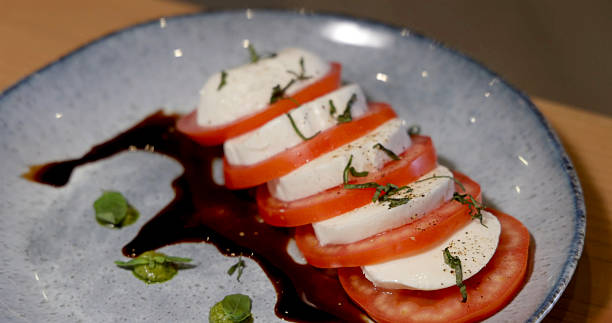 Caprese salad with fresh mozzarella, tomatoes, basil on plate. Italian