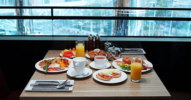 Luxury hotel breakfast buffet with assorted plates of eggs, pastries,