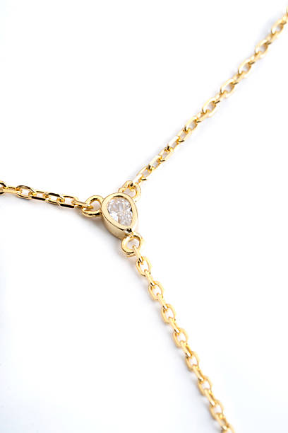 istock Gold necklace chain featuring teardrop diamond pendant on white background 2232518708