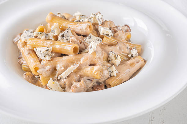 istock Penne pasta served with creamy walnut blue cheese sauce on white plate 2232519997