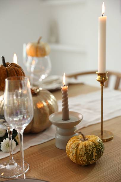 istock Stylish table setting with glasses, candles and autumn decor in dining room 2232521118