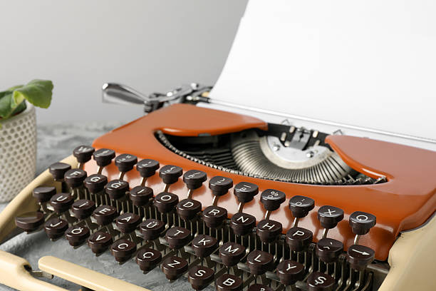 Vintage typewriter with sheet of paper on grey table, closeup