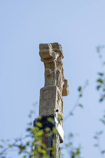 Stone cross standing tall against blue sky