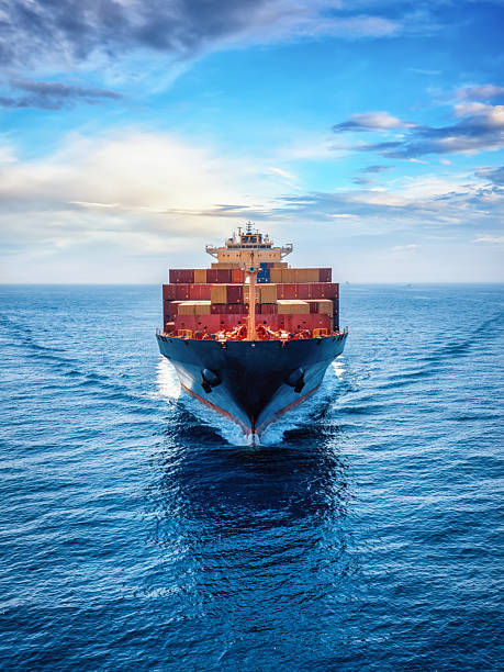 front view of a loaded container cargo vessel traveling over the ocean - containerschip stockfoto's en -beelden