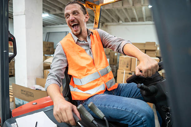 istock Worker Smiling and Driving Forklift in a Warehouse Environment 2232527737