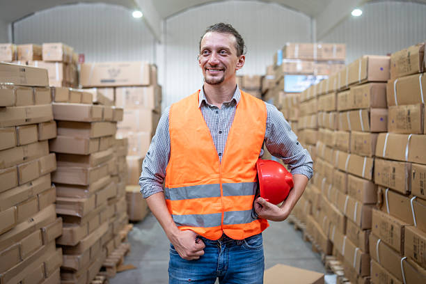 istock Warehouse Worker Holding Safety Helmet in Storage Facility 2232528123
